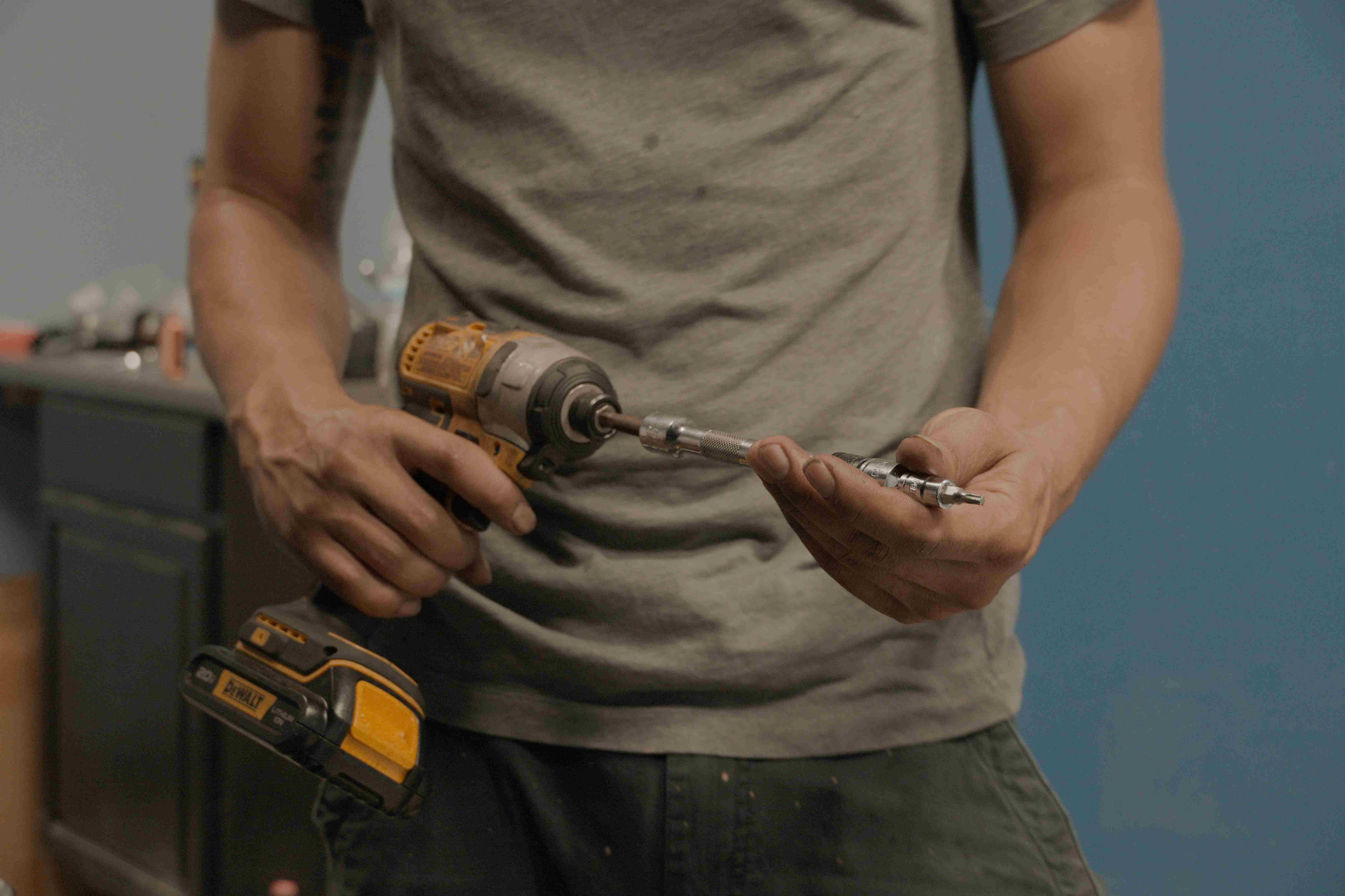 Mason Mechanics technician loading a bit into a cordless impact driver during a repair